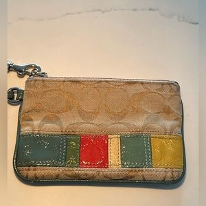 Coach C jacquard wristlet with green strap.